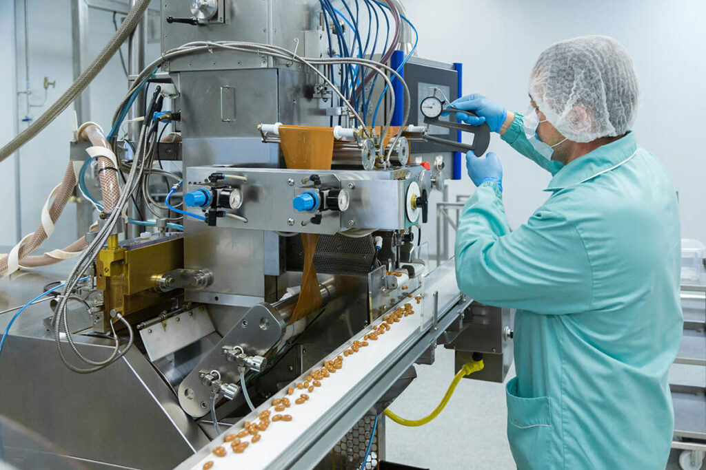 Someone working on a machine to process food.