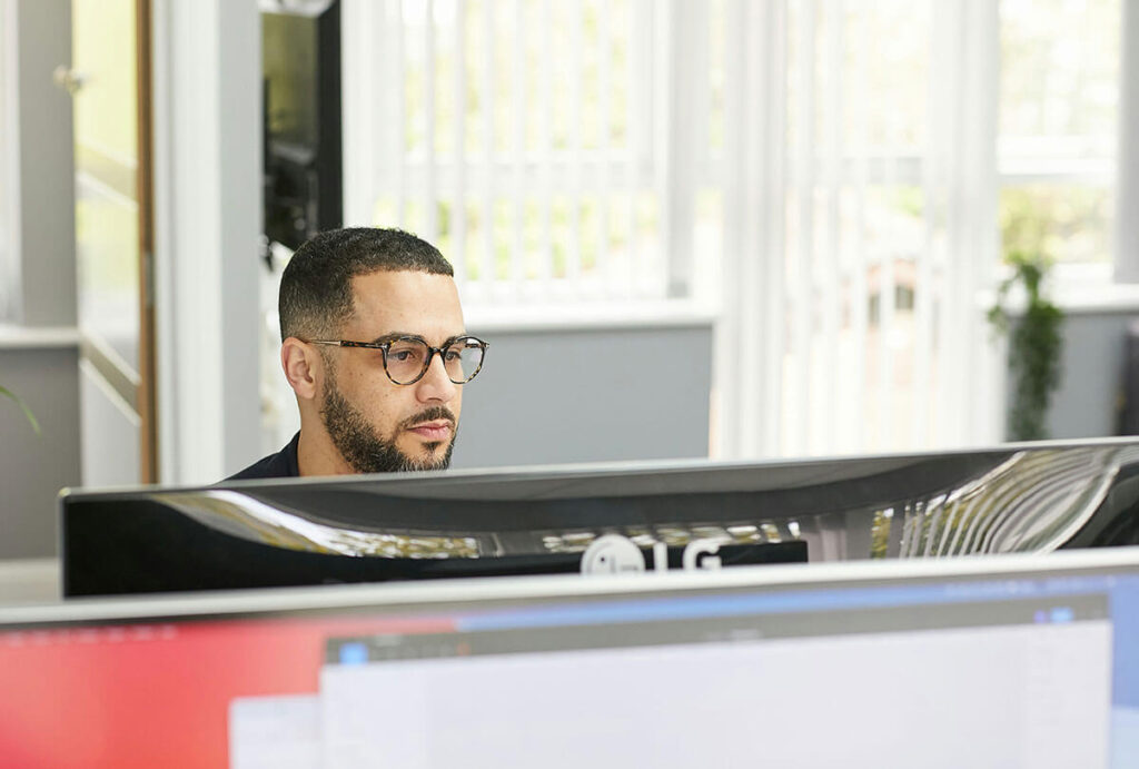 Man working at a desktop monitor.